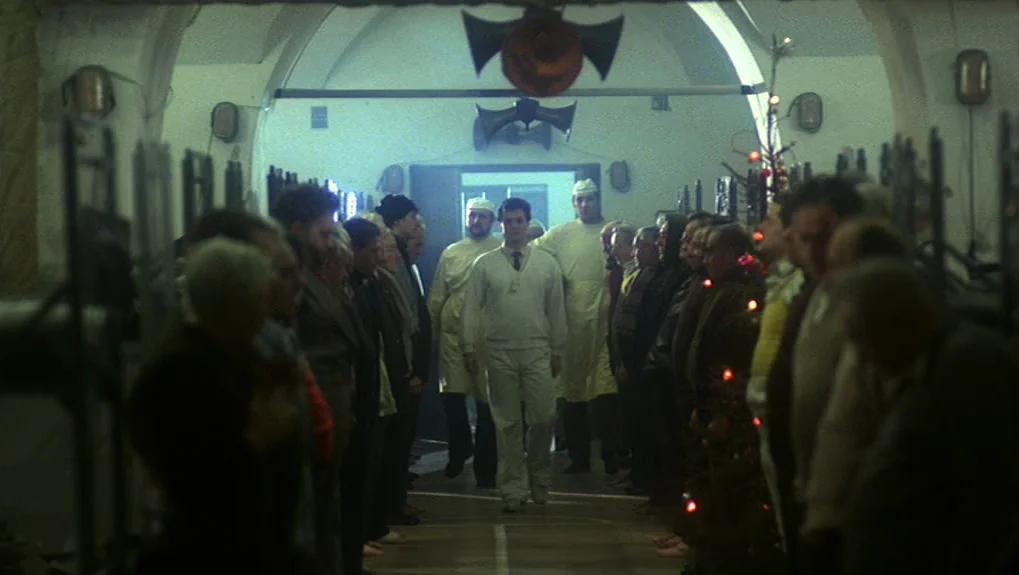 The War of the Worlds: Next Century (1981) movie still: medium — A long, dimly lit institutional hall with vaulted ceilings and rows of people…