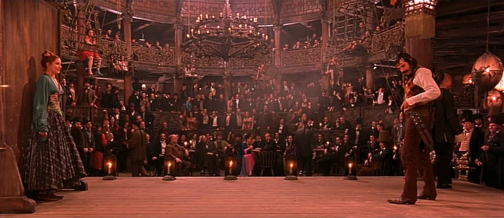 Gangs of New York (2002) movie still: wide — A tiered 19th-century wooden music hall is filled with a crowded audience watching a performance. A…