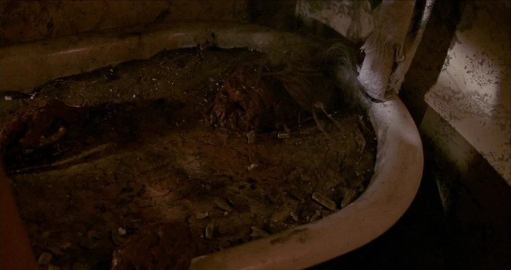 The Silence Of The Lambs (1991) movie still: medium — A neglected bathroom features an old tub filled with a dark, sludge-like substance. A mass of…
