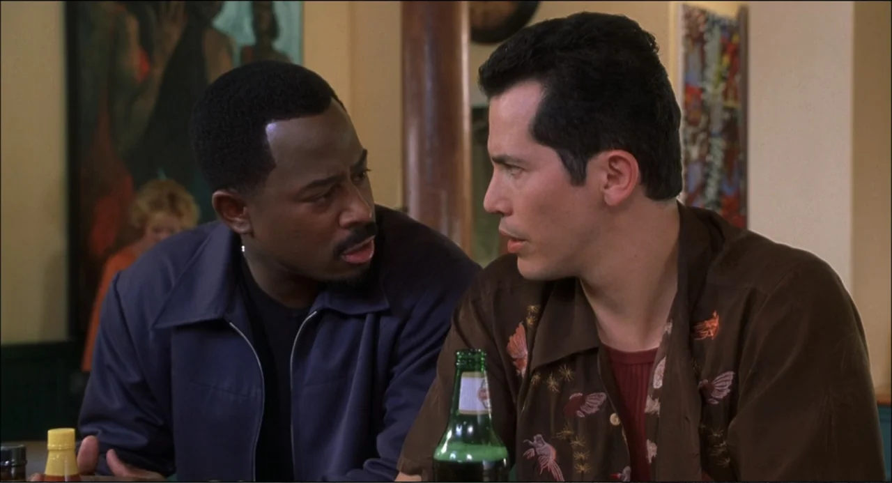What's the Worst That Could Happen? (2001) movie still: medium — A restaurant booth with two men seated at a table near a wall. The men converse…