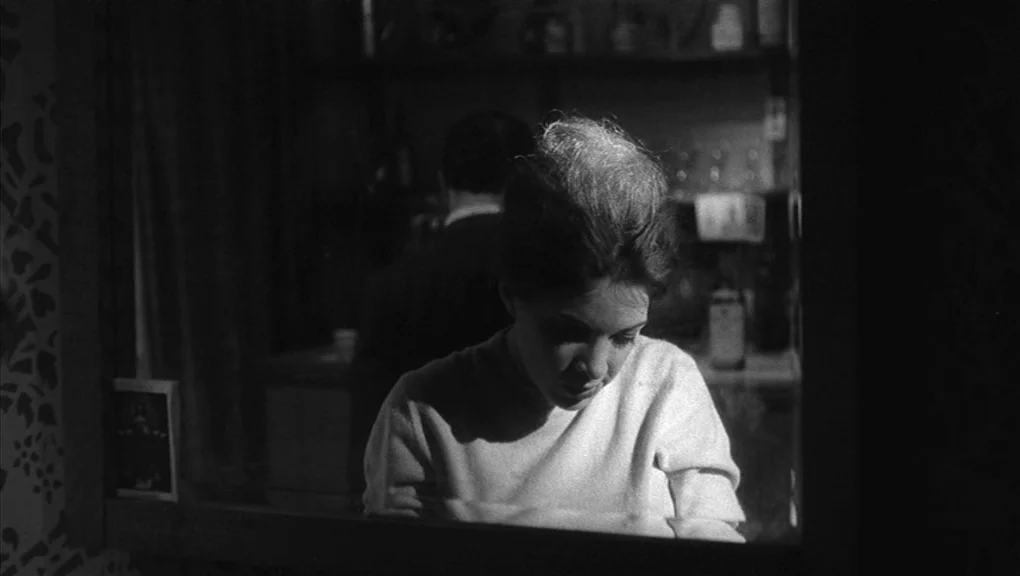 Who’s That Knocking At My Door (1967) movie still: A pensive woman is captured in a medium close-up via her reflection in a mirror, her face softly…