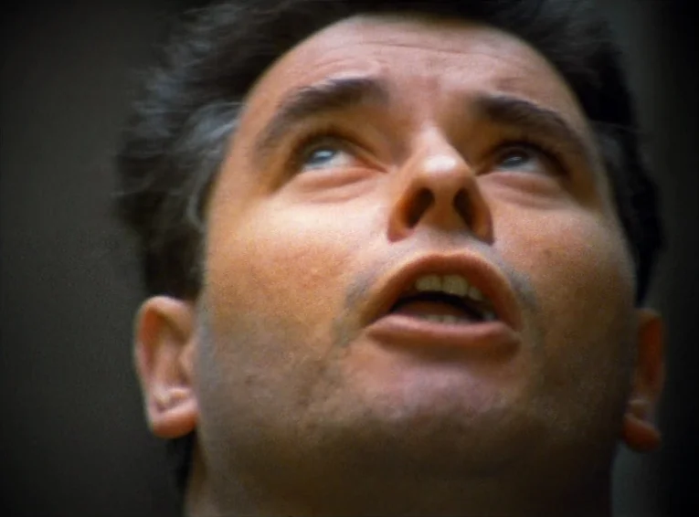 The Merchant Of The Four Seasons (1971) movie still: closeup — A man's face fills the frame against a dark, out-of-focus background. The subject is…