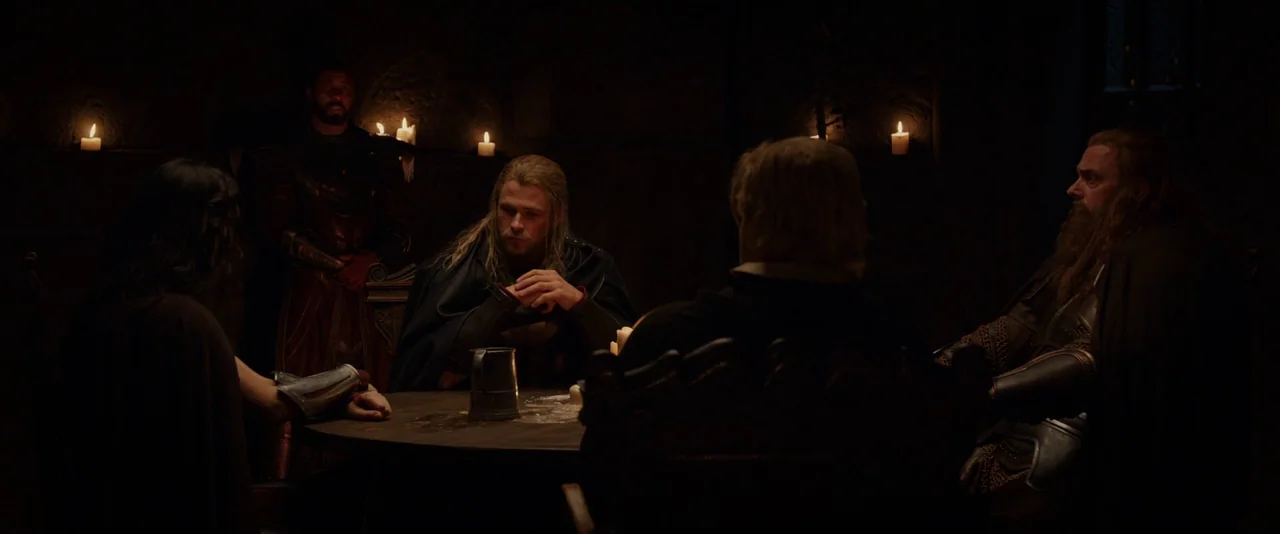 Thor: The Dark World (2013) movie still: medium — A group of warriors in medieval-style armor sits at a round wooden table. They are gathered in a…