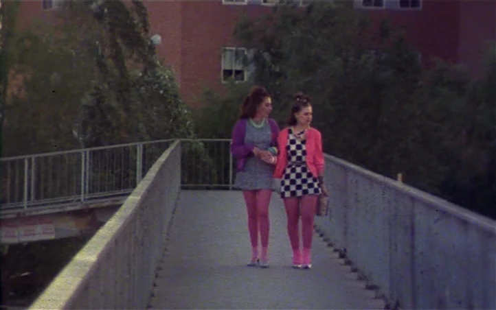Pepi, Luci, Bom and Other Girls Like Mom (1980) movie still: fullbody — A concrete pedestrian bridge spans a path near a brick building with mature…