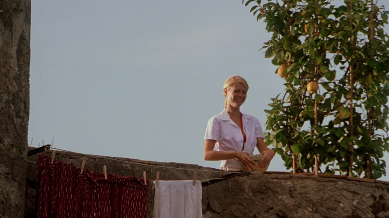 The Talented Mr. Ripley (1999) movie still: medium — A sunny stone rooftop terrace features a small lemon tree in a wooden pot. A young woman stands…