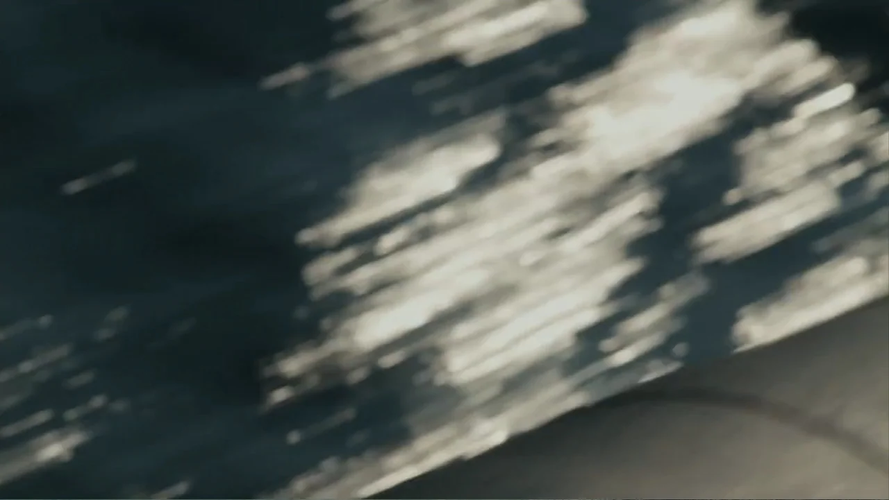 REM (2019) movie still: establishing — Dark water moves rapidly under the glow of moonlight. The surface reflects light in distorted patterns.