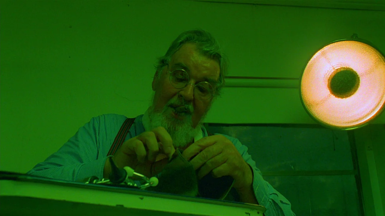 Paris, Texas (1984) movie still: medium — An interior space bathed in intense green light with a medical examination lamp visible. An older man with…