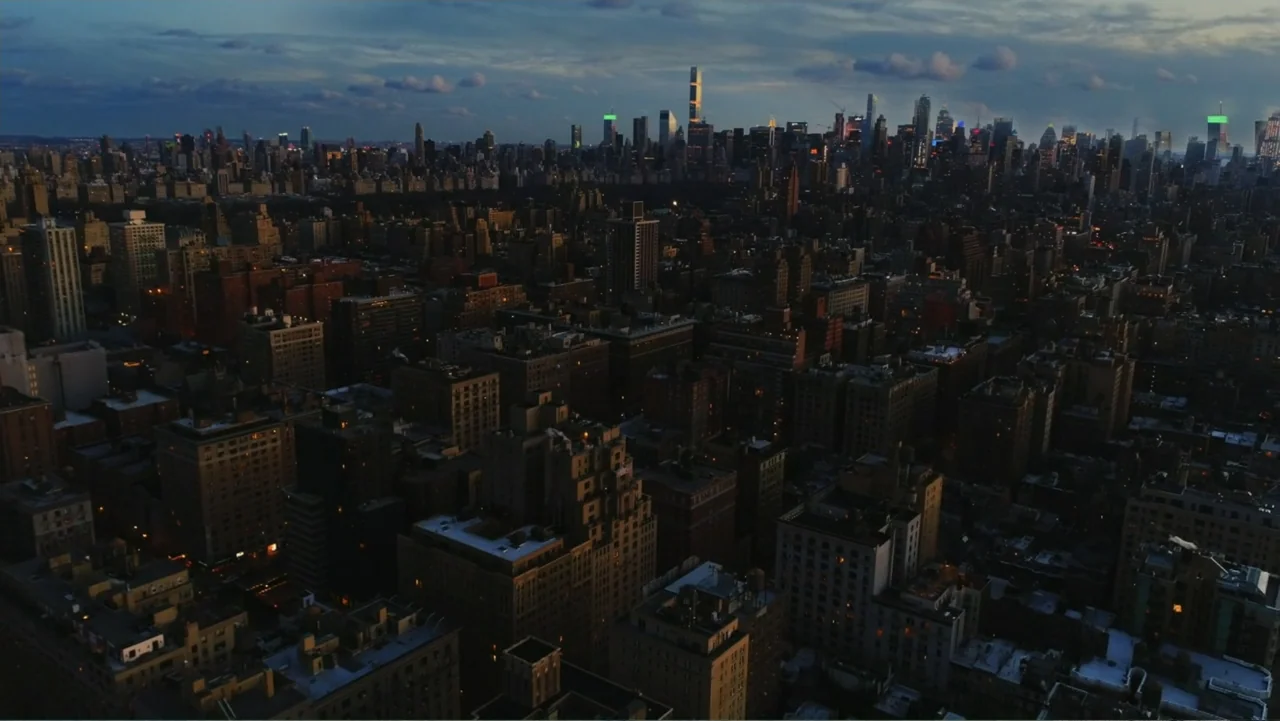 Between the World and Me (2020) movie still: establishing — A vast aerial view of the New York City skyline at dusk. Numerous skyscrapers and…