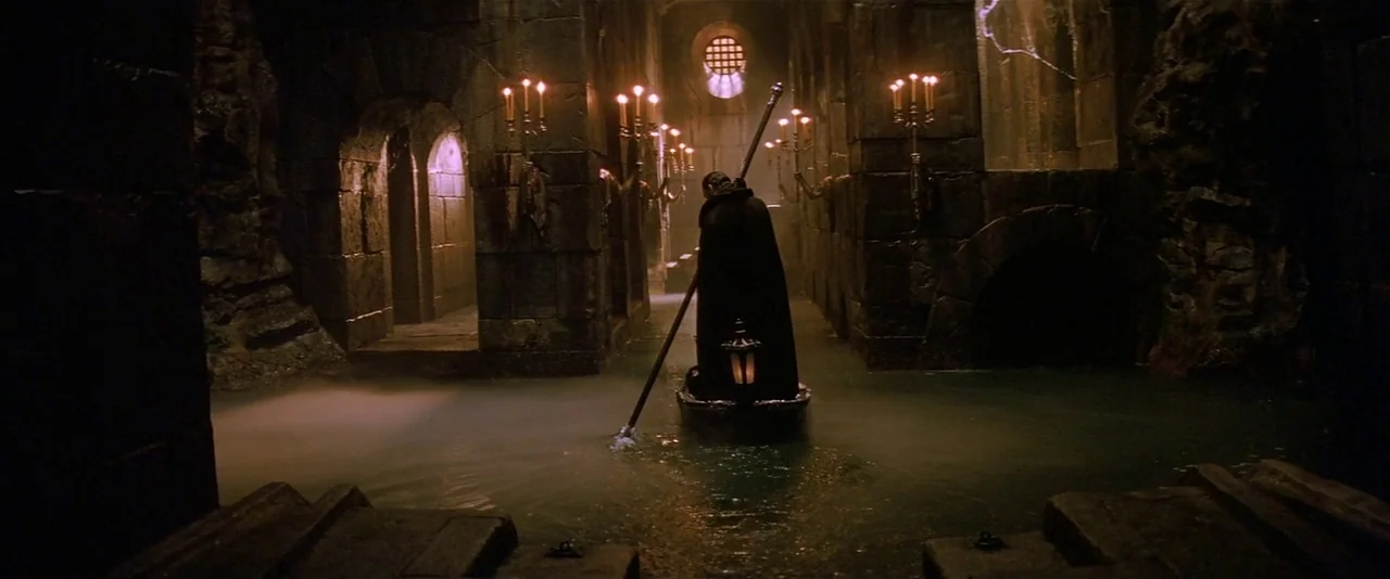 The Phantom of the Opera (2004) movie still: wide — An underground stone channel filled with water flows through a dark arched corridor. A lone…