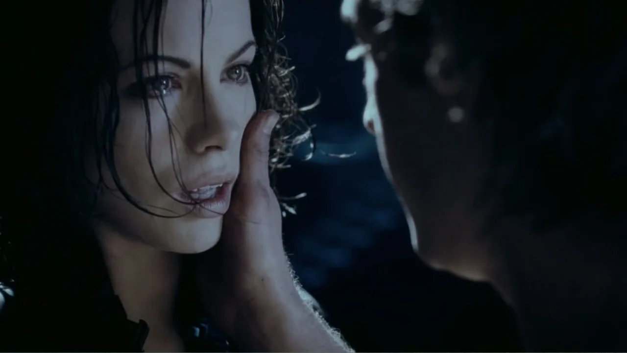 Underworld: Blood Wars (2016) movie still: closeup — A dark outdoor space at night with a person standing close to another. A man's hand reaches out…
