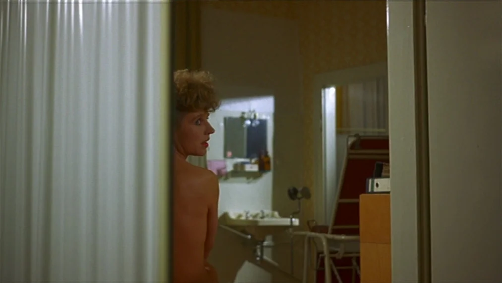 The Marriage of Maria Braun (1979) movie still: medium — A clinical room with light-colored walls contains a sink and a medical examination chair. A…