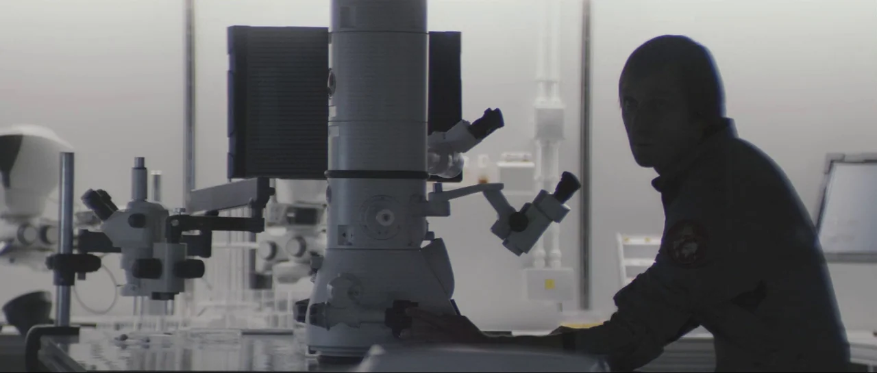 The Last Days On Mars (2013) movie still: medium — A sterile, brightly lit laboratory setting features complex scientific machinery in the center. A…
