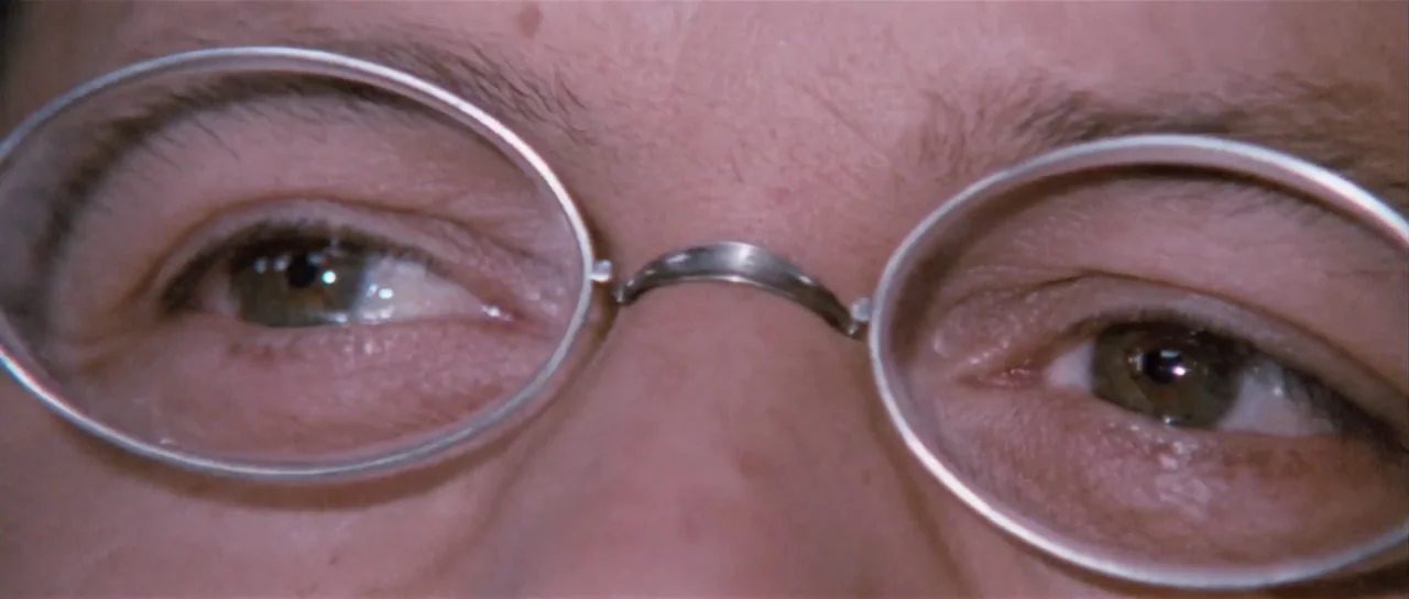 Duck, You Sucker (1971) movie still: closeup — A close-up view of a person's eyes framed by thin silver spectacle rims. The person looks directly…