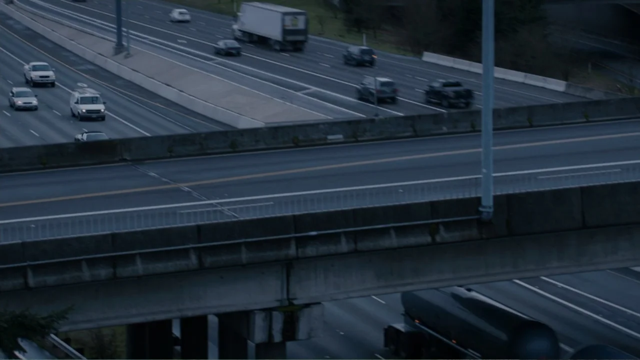 Fifty Shades of Grey (2015) movie still: establishing — A complex concrete highway overpass structure spans over a lower motorway level. Numerous…