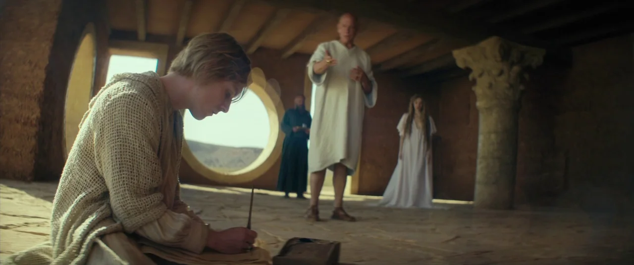 Seneca: On The Creation Of Earthquakes (2023) movie still: medium — A stone chamber with circular windows overlooks a desert landscape under a clear…