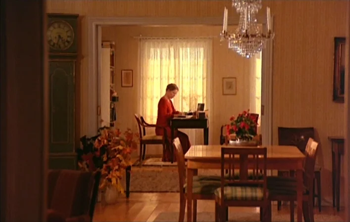 Autumn Sonata (1978) movie still: wide — A spacious home interior features warm wooden flooring and yellow walls with period accents. A woman in a…