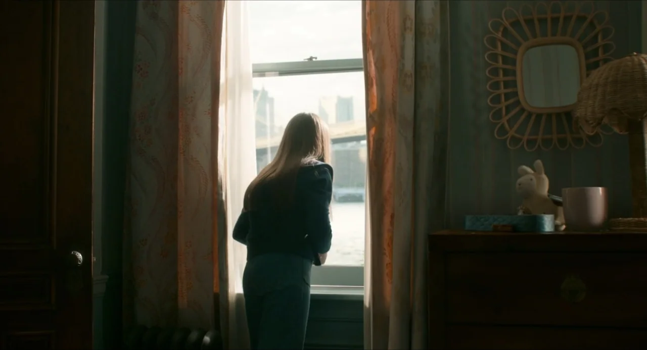 IF (2024) movie still: medium — A quiet room featuring patterned curtains and a dresser with a mirror and small toys. A young girl stands by the…