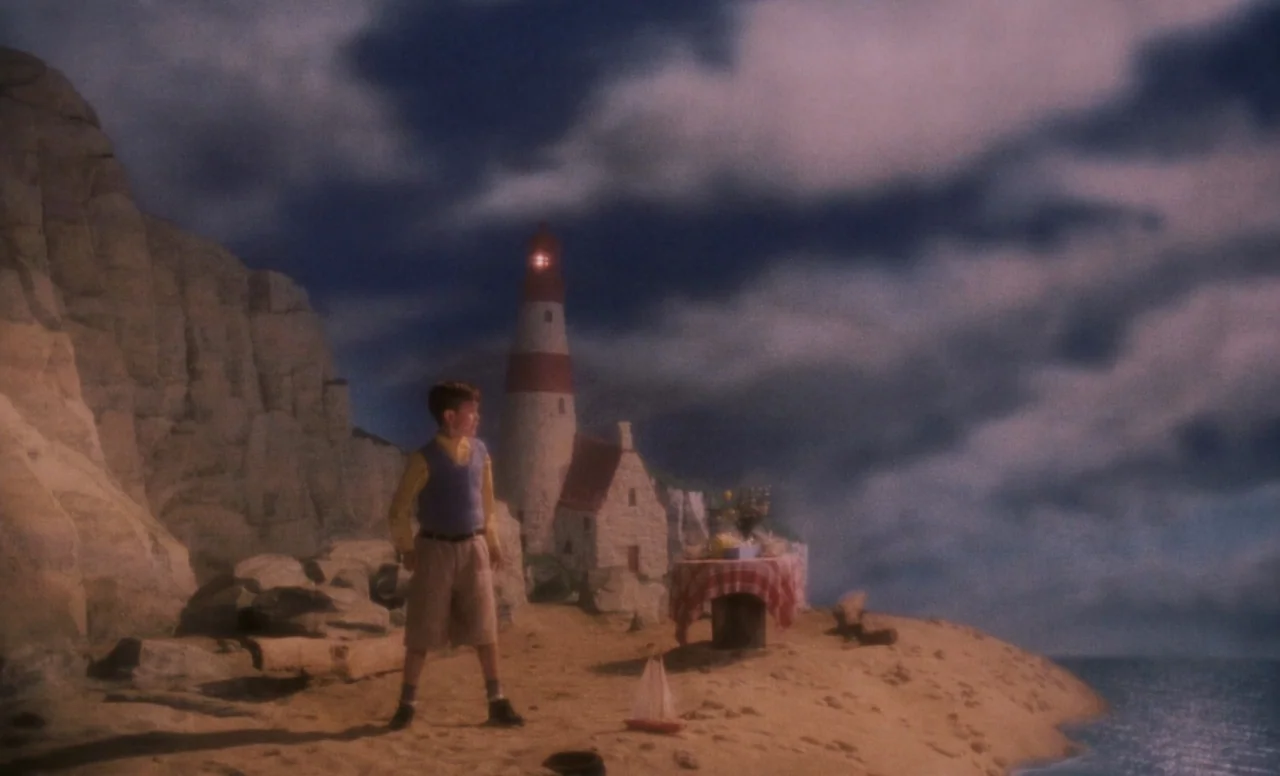 James and the Giant Peach (1996) movie still: wide — A sandy beach shoreline features white limestone cliffs and a red-and-white striped lighthouse…