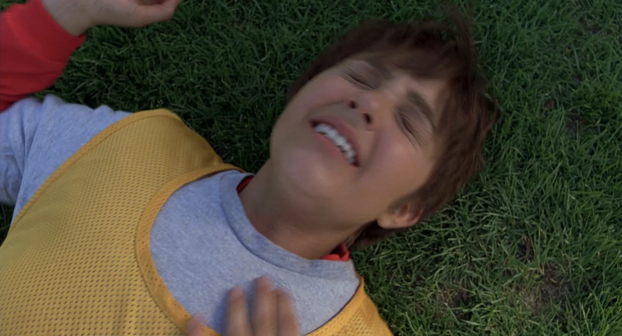 She's the Man (2006) movie still: closeup — A patch of green grass serves as the backdrop for a prone boy. The subject lies on his back with his…