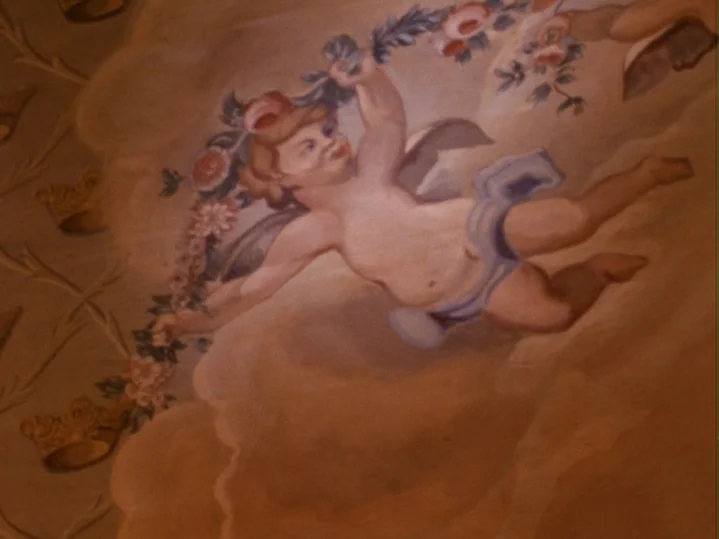 The Magic Flute (1975) movie still: closeup — A painted fresco on a ceiling features a cherub figure in clouds. The figure holds a floral garland…