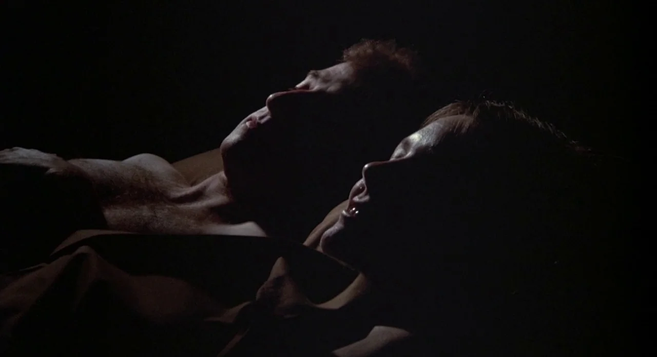 Annie Hall (1977) movie still: closeup — A close-up shot captures the heads and upper torsos of two people resting. They lie side by side on their…
