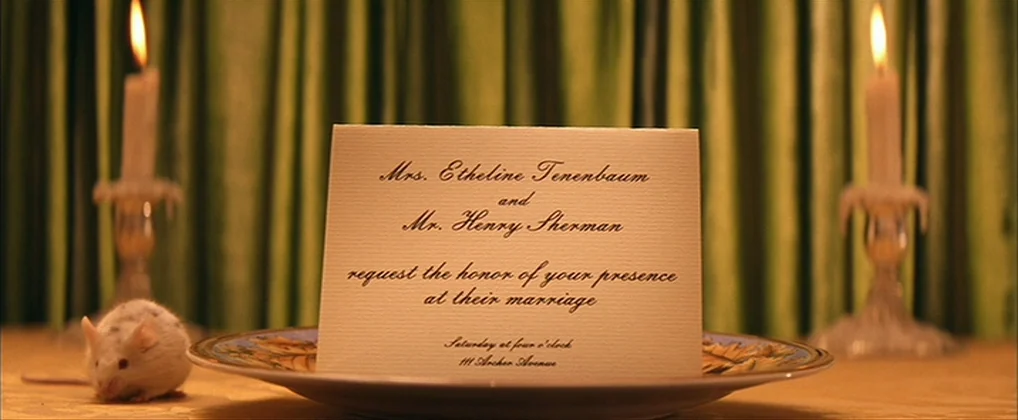The Royal Tenenbaums (2001) movie still: closeup — A wedding invitation rests on a plate in front of draped green velvet curtains. Two lit candles…
