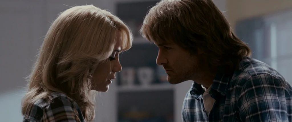 MacGruber (2010) movie still: medium — A man and woman stand facing each other within a residential indoor setting. Both individuals are dressed in…