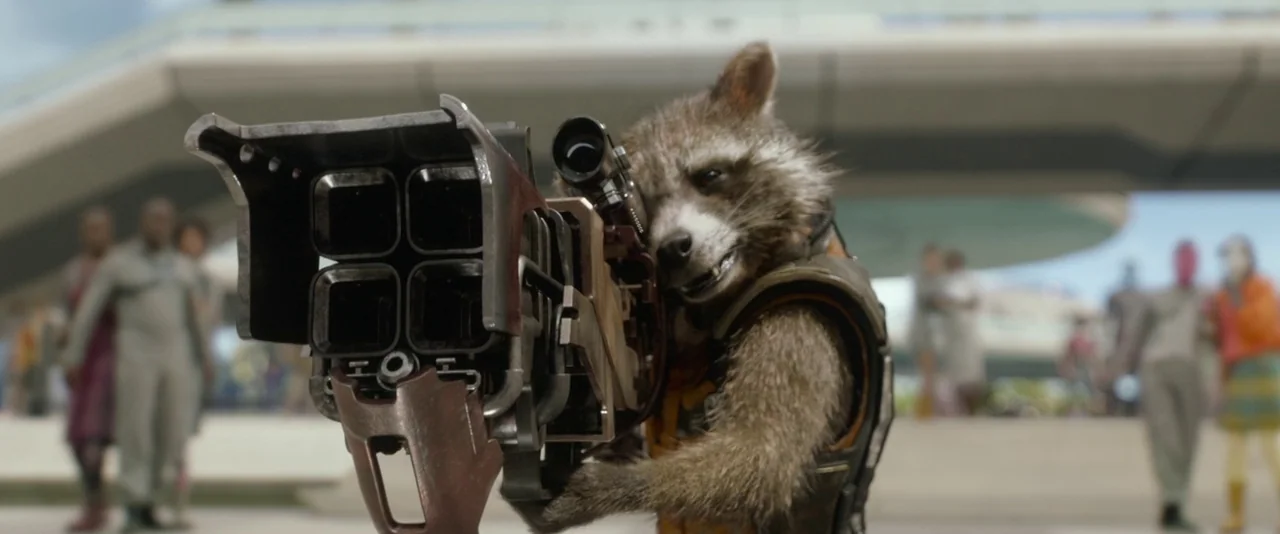 Guardians of the Galaxy (2014) movie still: medium — A raccoon-like character stands in a modern, starkly designed outdoor pedestrian plaza. The…