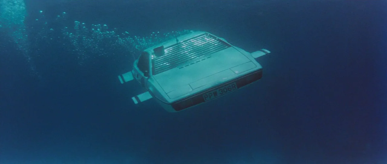 The Spy Who Loved Me (1977) movie still: wide — A white sports car converted into a submarine moves through deep blue water. Air bubbles trail from…