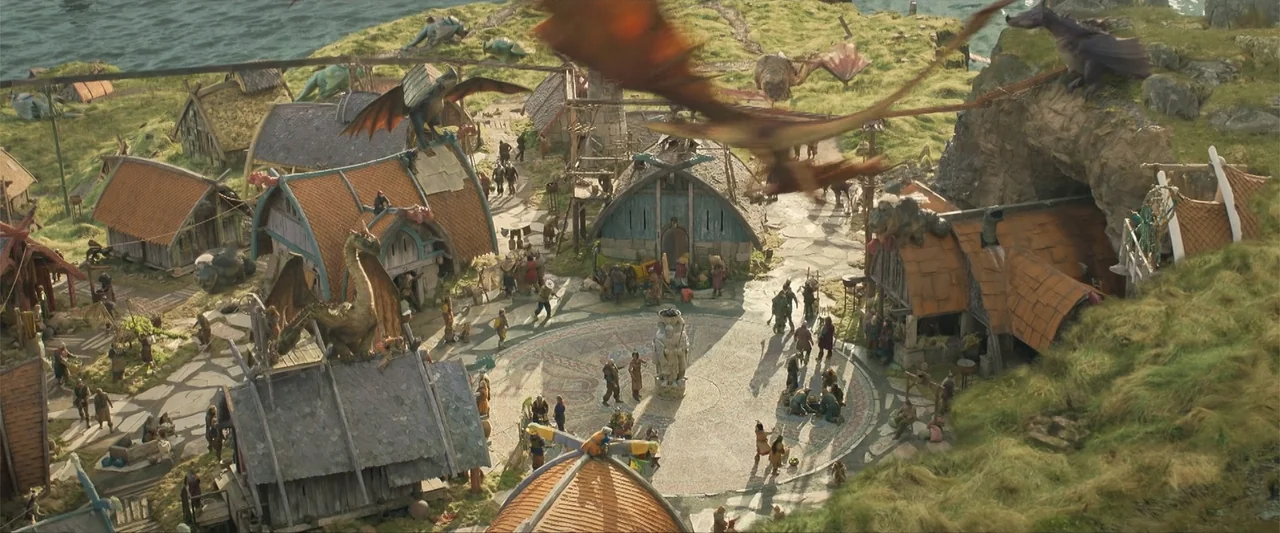 How to Train Your Dragon (2025) movie still: wide — A high-angle view shows a fantasy village with thatched roofs and stone paths. Dragons perch on…