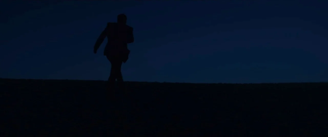 Happy New Year, Colin Burstead (2018) movie still: wide — A dark, featureless field stretches across the frame under a deep blue night sky. A lone…
