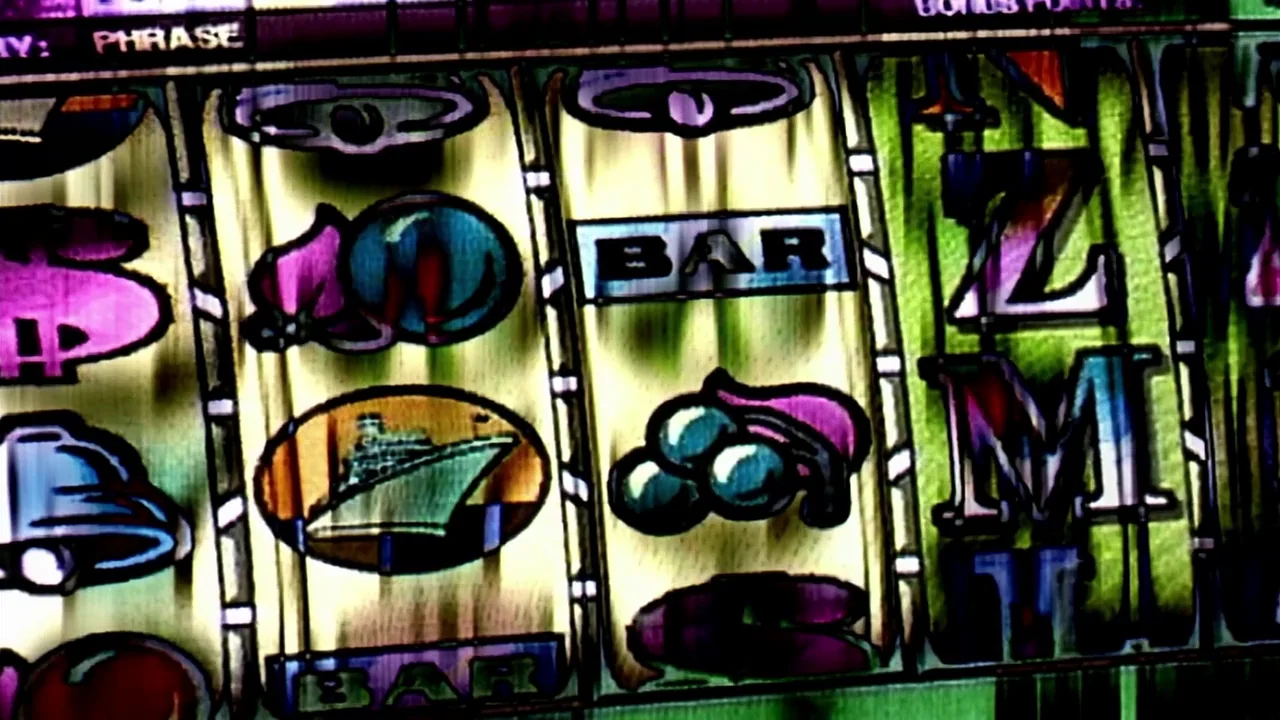 Naqoyquatsi (2002) movie still: closeup — The rotating reels of a mechanical slot machine display various gambling symbols. Painted icons of bells,…