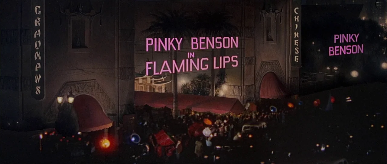What A Way To Go! (1964) movie still: establishing — The exterior of Grauman's Chinese Theatre is decorated with large pink neon movie signage. A…