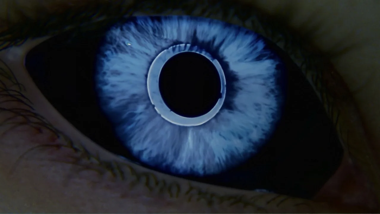 Underworld: Blood Wars (2016) movie still: closeup — An extreme close-up of a human eye with a bright blue iris. The pupil is dilated and captures a…