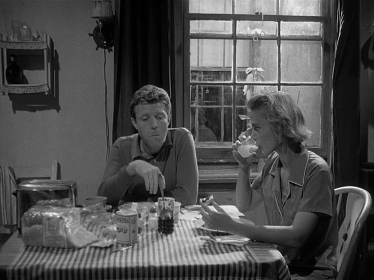 Killer’s Kiss (1955) movie still: medium — A small dining area with a window showing a dark exterior at night. A man and a woman sit at a table…