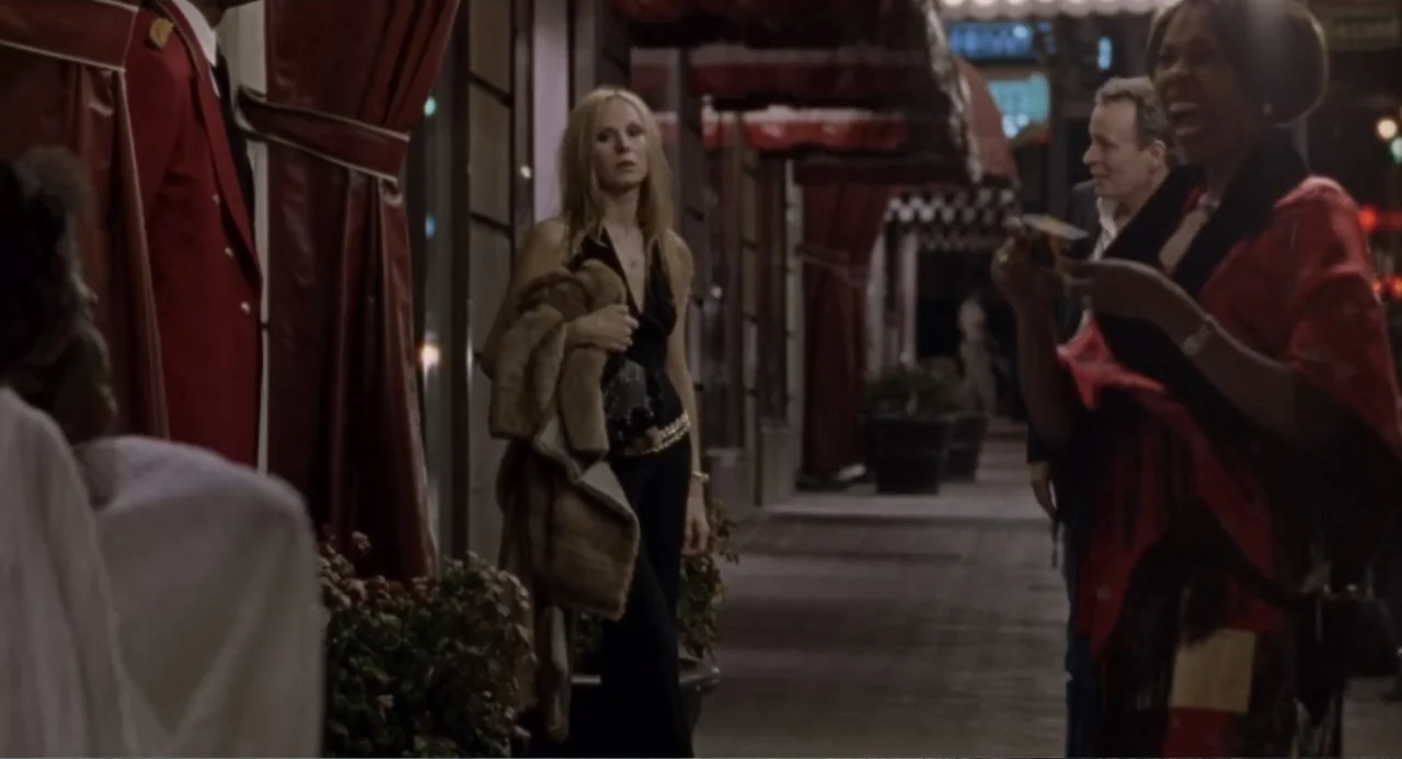 Forty Shades of Blue (2005) movie still: medium — A hotel entrance at night features large red curtains and architectural columns along the path.…