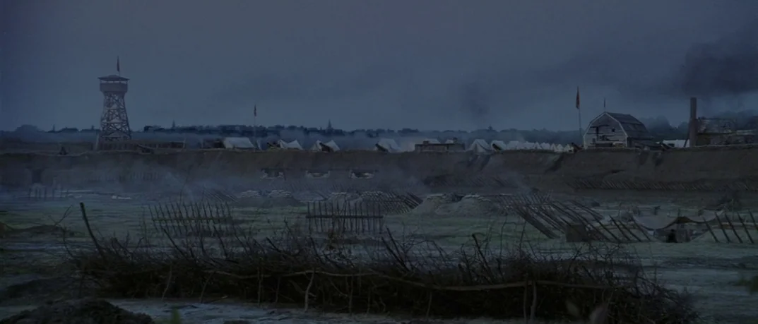 Cold Mountain (2003) movie still: establishing — A military fortification with earthen ramparts and a wooden observation tower stands at dawn. Smoke…