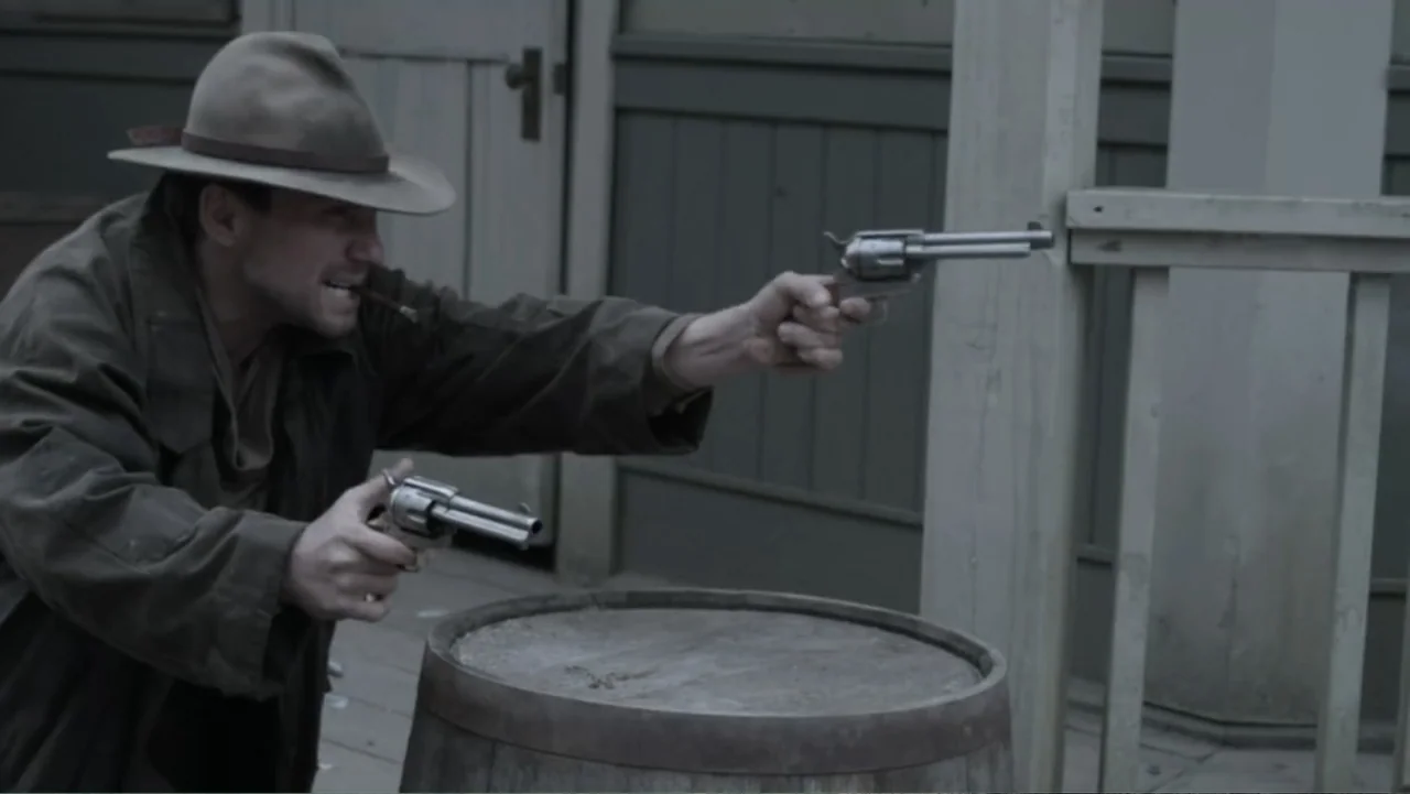 Dawn Rider (2012) movie still: medium — A wooden porch area features a large rounded barrel positioned in the foreground. A man wearing a fedora…