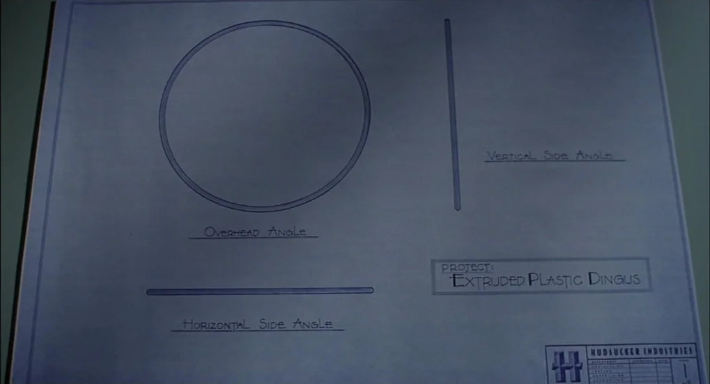 The Hudsucker Proxy (1994) movie still: closeup — A blueprint on paper details the design of an Extruded Plastic Dingus product. Diagrams show an…