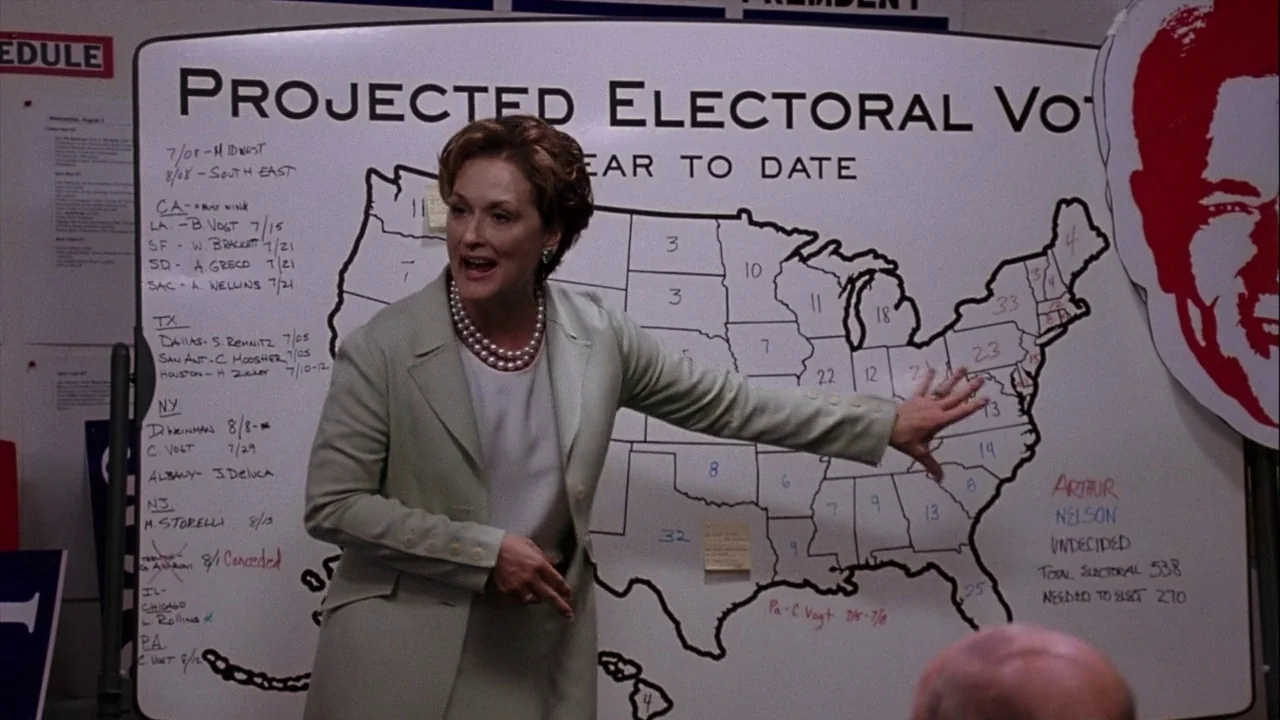 The Manchurian Candidate (2004) movie still: medium — A campaign war room features a large whiteboard displaying electoral vote projections on a…