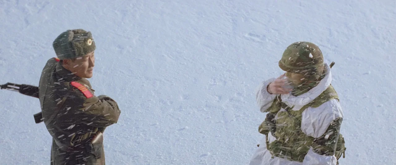 Joint Security Area (2000) movie still: fullbody — An open snowy field serves as the location for a meeting between two soldiers. A man in a brown…