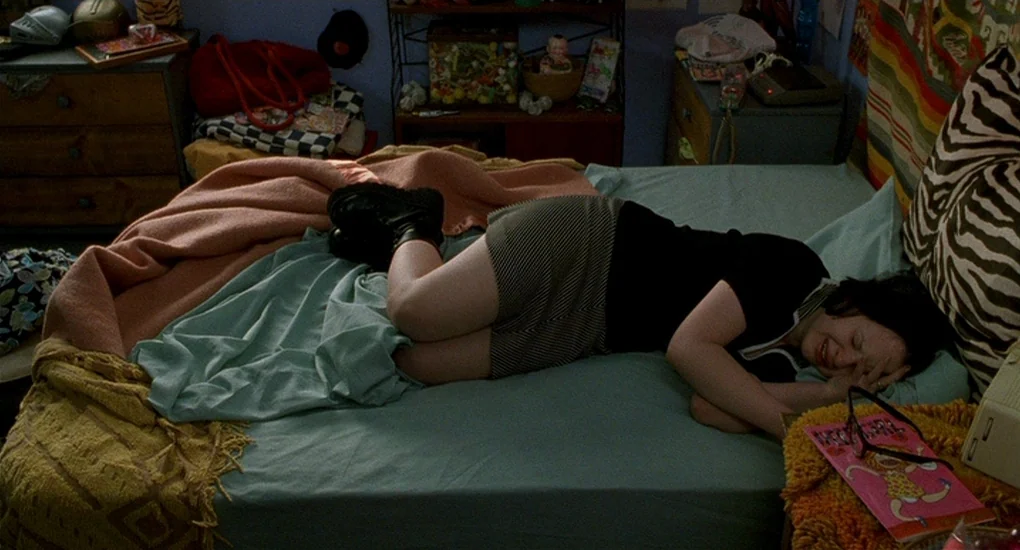 Ghost World (2001) movie still: medium — A cluttered teenage bedroom filled with various knick-knacks and personal belongings on surfaces. A girl…