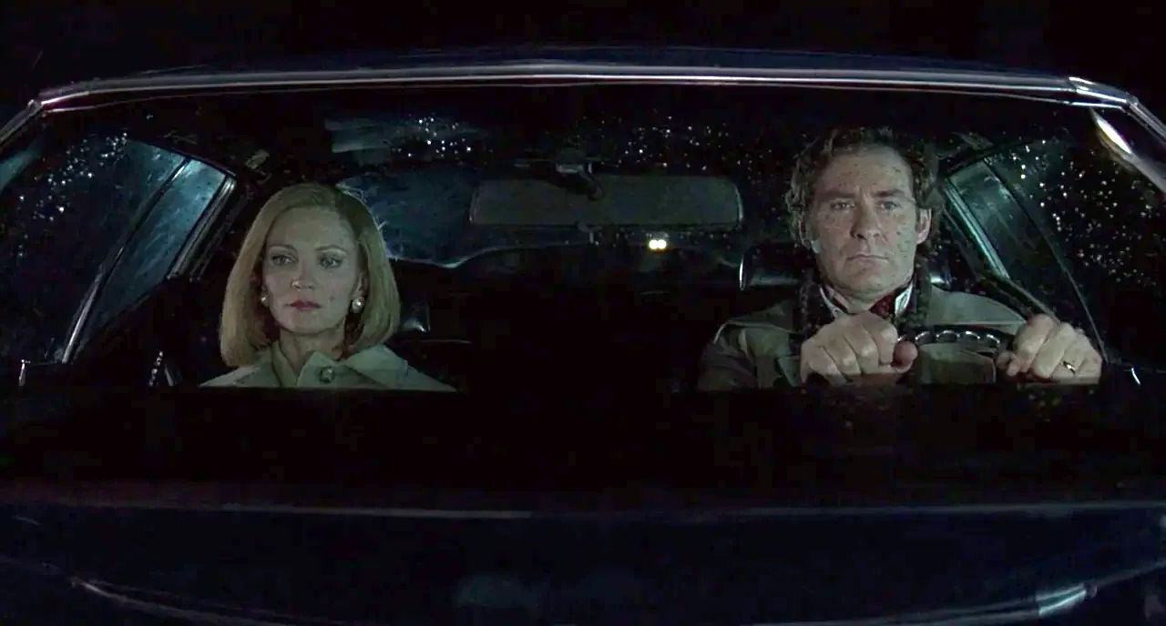 The Ice Storm (1997) movie still: medium — The interior of a car at night seen from the windshield perspective. A man and a woman sit together in…