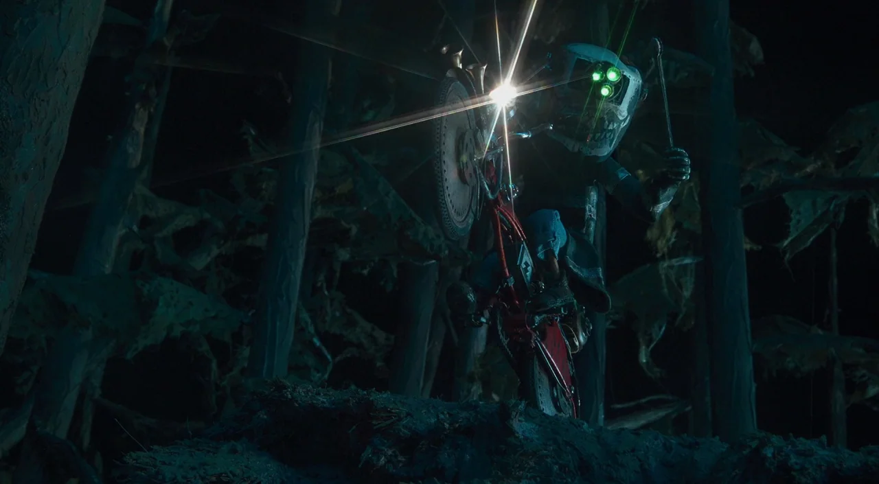 Coraline (2009) movie still: medium — A dark, textured woodland area is shrouded in shadows and thick, gnarled tree trunks. A figure wearing a…
