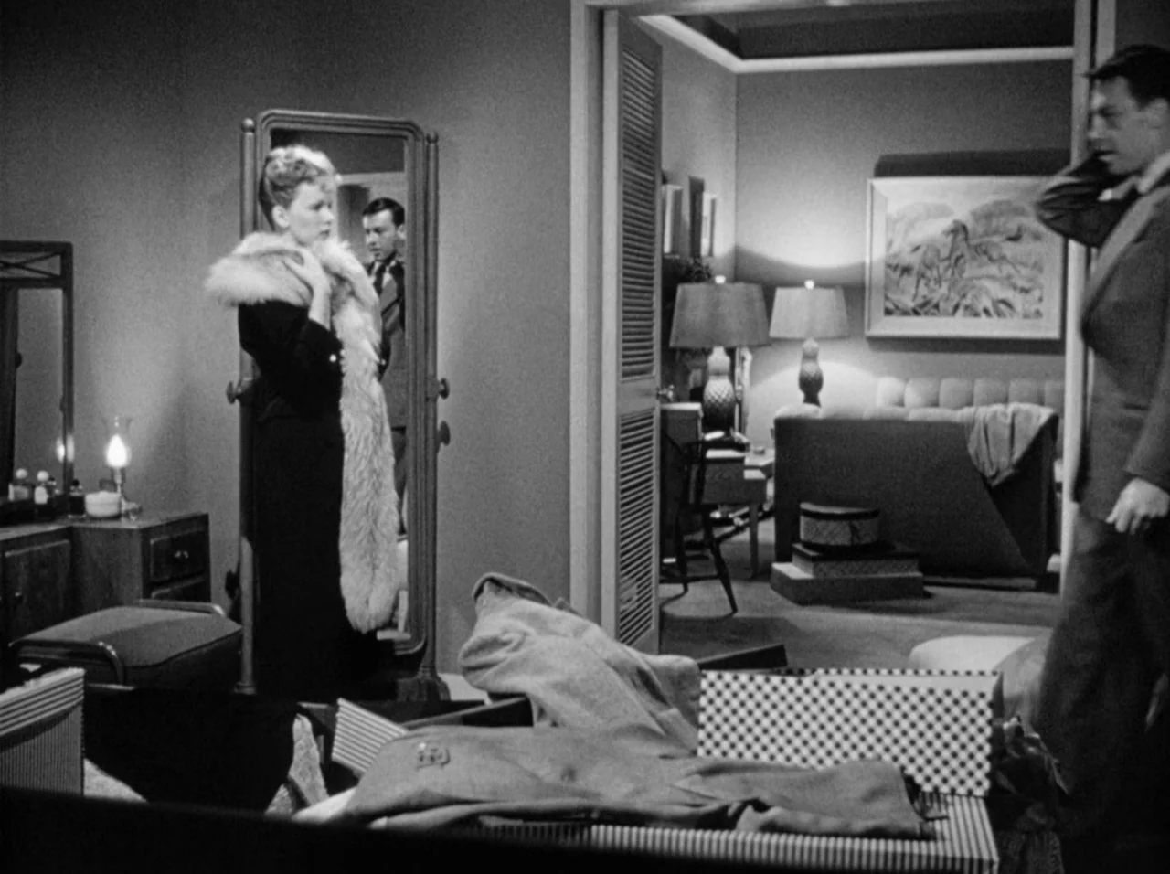 Gun Crazy (1950) movie still: medium — A well-lit dressing area connects to a second room featuring lamps and furniture. A woman in a fur stole…