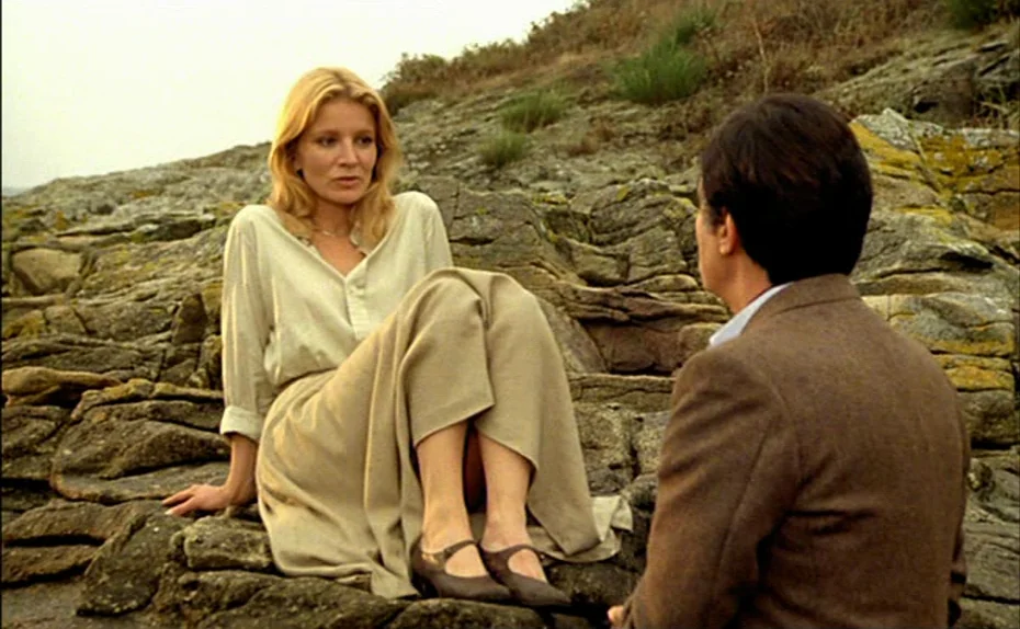 My American Uncle (Mon oncle d’Amérique) (1980) movie still: medium — A man and woman are seated on uneven, moss-covered rocks on a desolate…