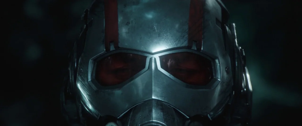 Ant-Man and the Wasp (2018) movie still: closeup — A close view of a metallic tactical helmet with red eye lenses. The surface of the helmet shows…