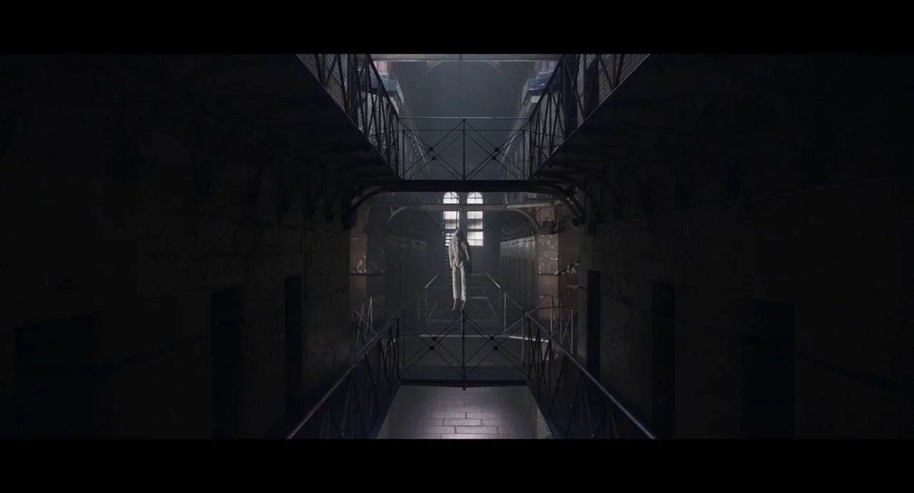 True History of the Kelly Gang (2019) movie still: wide — A long, dark multi-story gallery features tiered iron catwalks and repeating dark…