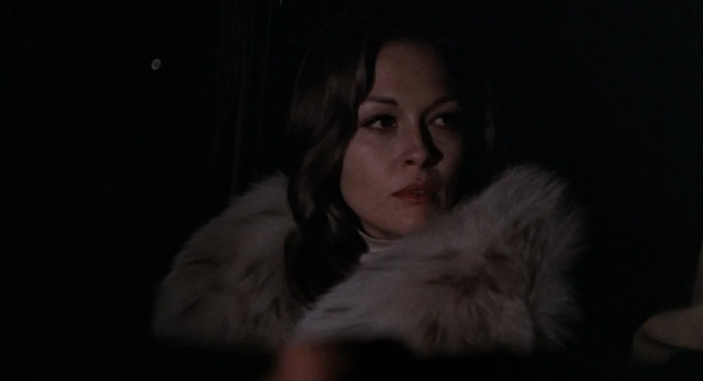 Puzzle of a Downfall Child (1970) movie still: closeup — The interior of a dark car at night with minimal ambient light. A woman wearing a…