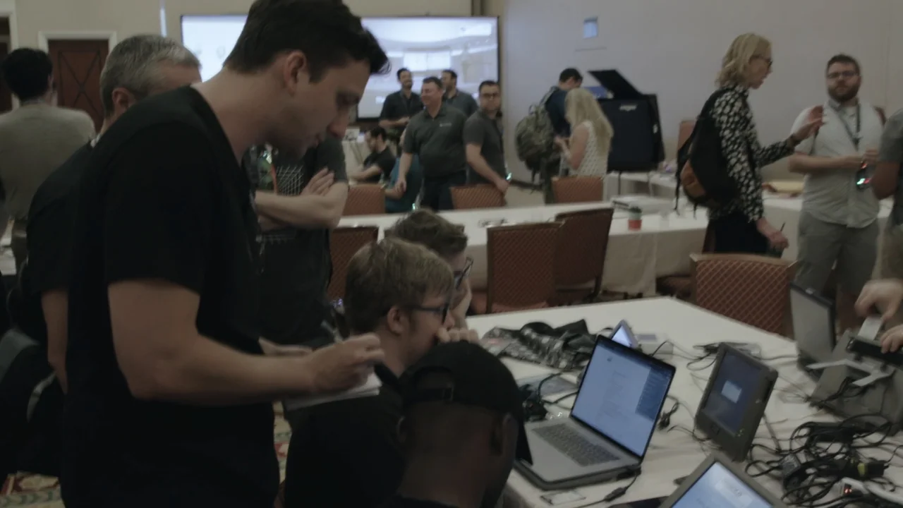 Kill Chain: The Cyber War on America's Elections (2020) movie still: medium — A crowded professional event features people gathered around tables…